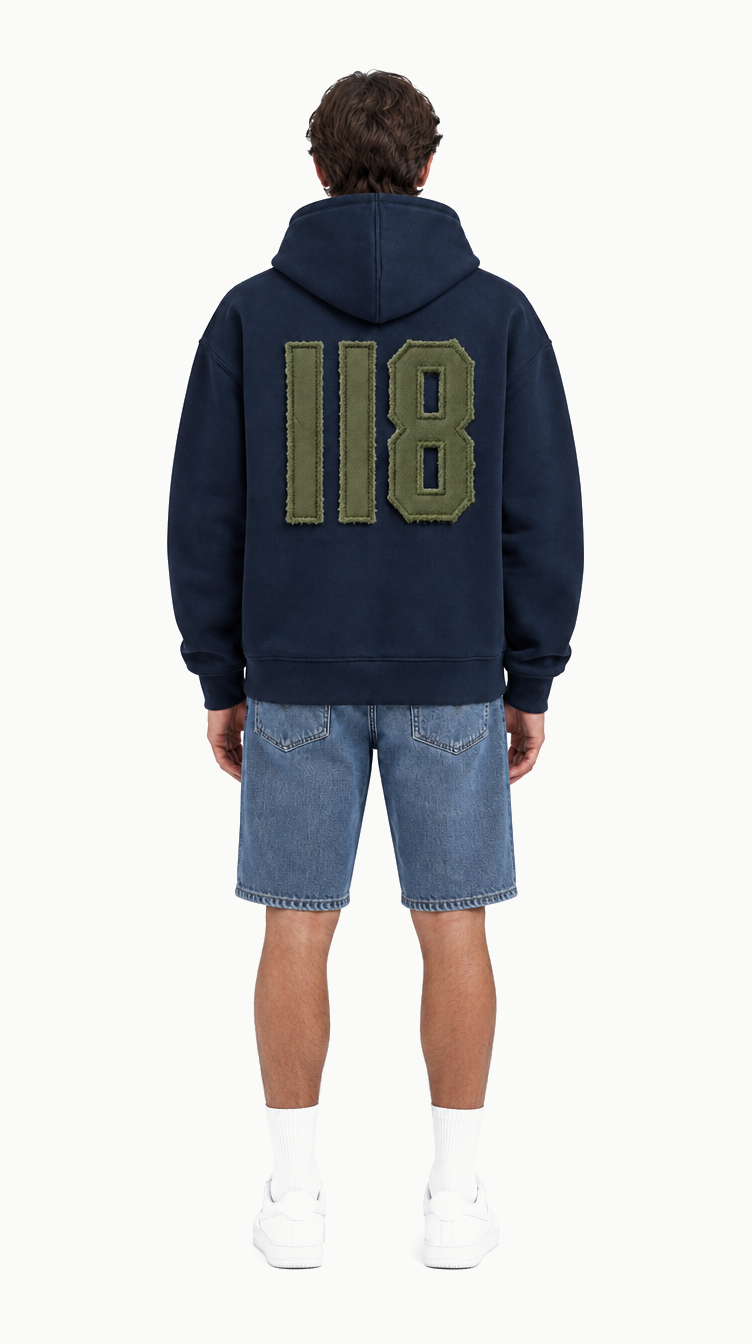 De 118 Zipped Hoodie van achteren met de Olive Branch patch, op model, studio-opname