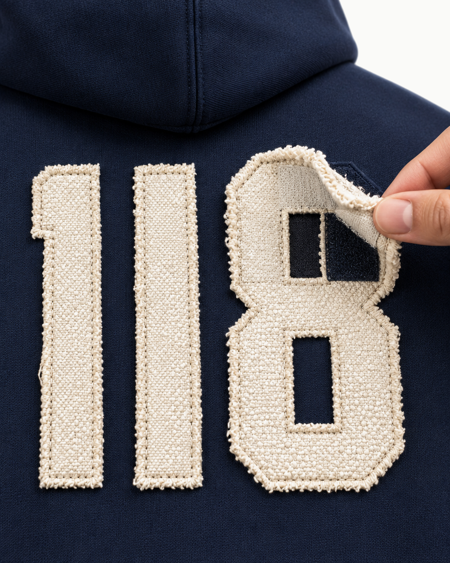 Hand die een hoek van de 118-patch optilt, klittenband zichtbaar